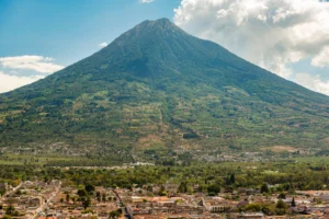 Panoramic view of Antigua Guatemala with a large green volcano rising behind the city